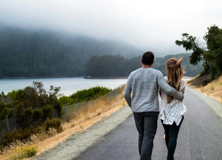 A couple walking beside a lake